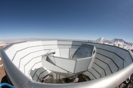 The Atacama Cosmology Telescope viewed from the top of the outer ground screen. The top half of the segmented, primary mirror can be seen above the inner ground screen that moves with the telescope.