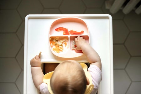 Overhead view of infant baby eating in the table for feeding