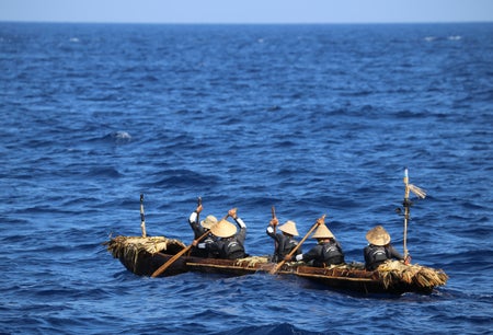 People row in a wooden canoe