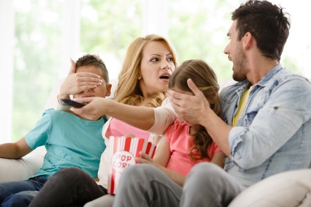 Parents cover their children's eyes while watching TV