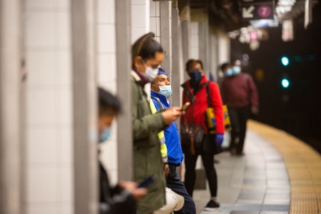 Masked commuters on subway platform
