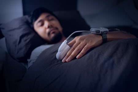 Asian Man Wearing a Pulse Oximeter in Bed