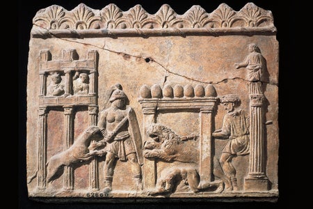 Roman relief in stone portraying gladiators and lions fighting as spectators watch from box seats above
