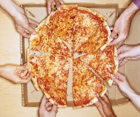 Pizza cut up many hands taking a piece