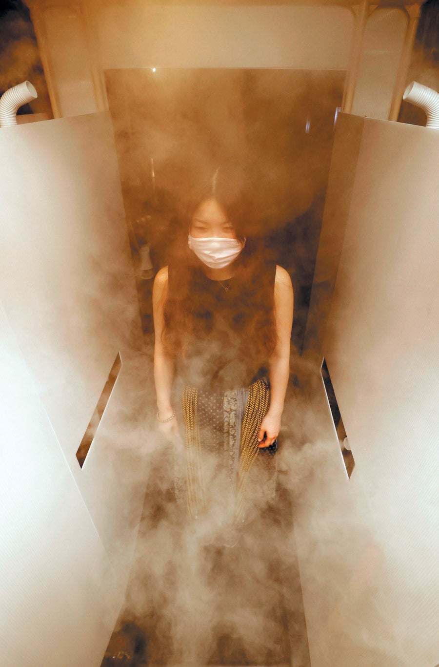 Person in narrow walkway filled with smoke or mist