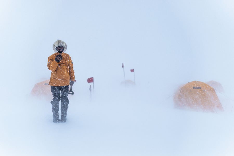 Person standing outside tents in snow