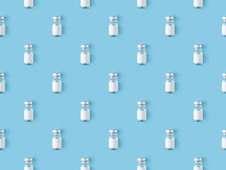 Seamless repetitive vaccine bottle on a blue background