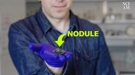 A man holds a small black rock in his outstretched hand and a yellow label over the image reads "nodule" and a yellow arrow points to the rock